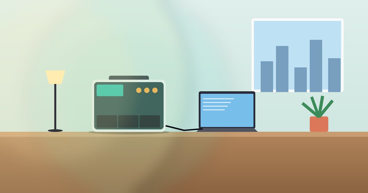 Portable power station on a desk beside a laptop and a lamp